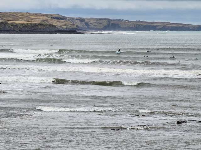 Longboarder on a shoulder high wave at Cornish point
